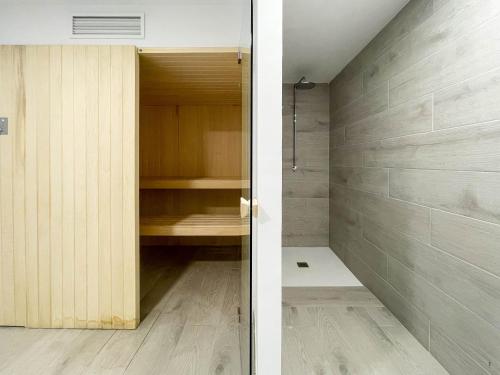 een badkamer met een inloopdouche en een houten kast bij Apartamento Seascape. Relax, lujo y vistas al mar. in Finestrat