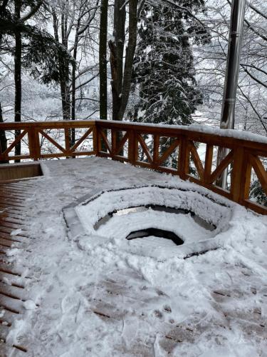 a snow covered patio with a wooden fence at Chalet Mlyn in Migovo