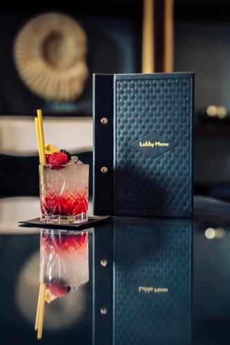 a drink sitting on a table next to a box at Columbus Hotel Monte-Carlo, Curio Collection by Hilton in Monte Carlo