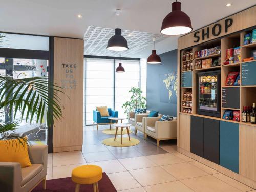 ル・アーヴルにあるAparthotel Adagio Access Le Havre Les Docksの部屋内のソファとテーブルのある店