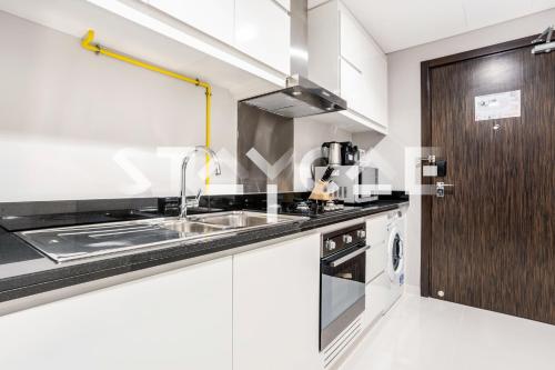 a kitchen with a sink and a stove at Staycae Holiday Homes - Artesia in Dubai