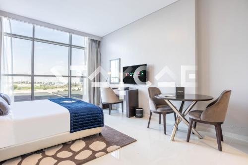 a bedroom with a bed and a table and chairs at Staycae Holiday Homes - Artesia in Dubai