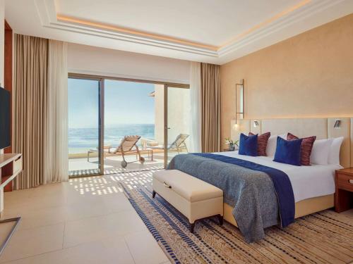 a hotel room with a bed and a view of the ocean at Fairmont Taghazout Bay in Taghazout