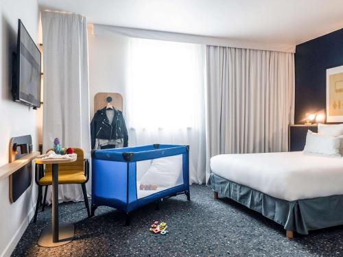 a hotel room with a bed and a table and a window at ibis Styles Paris Romainville in Romainville