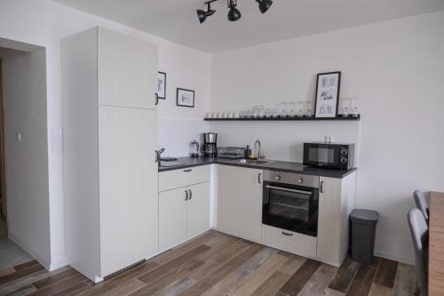 a kitchen with white cabinets and a microwave at Jachovka in Nová Ves v Horách