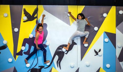 two girls are climbing on a rock wall at Tzuba Hotel in Ẕova