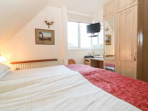 una camera con un grande letto e una televisione di Beech Apartment a Cheltenham