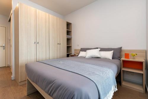 a bedroom with a large bed and a cabinet at For Students Only Studios Apartments at Middle Street in Portsmouth City Centre in Portsmouth