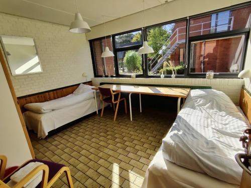 a dorm room with a desk and a bed and a table at Thy Event & Naturcenter in Frøstrup