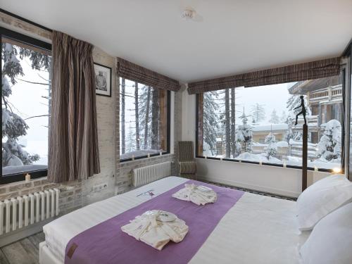 a bedroom with a bed with towels on it at Snow Lodge Hotel Courchevel 1850 in Courchevel