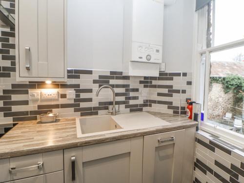 a kitchen counter with a sink and a window at The Flat in Barnard Castle