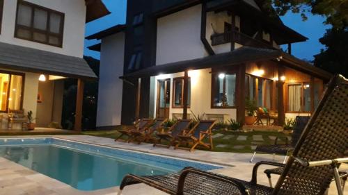 a house with a swimming pool in front of a house at Refúgio 755 in Florianópolis