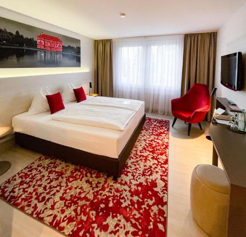 a bedroom with a large bed and a red rug at Ramada by Wyndham Dresden in Dresden