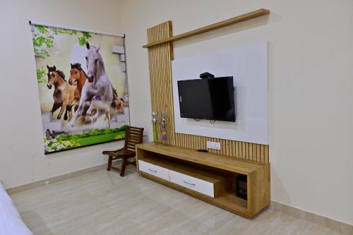a living room with a flat screen tv on a wall at Ideal Home stay in Amritsar