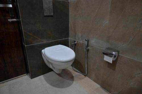 a bathroom with a white toilet in a stall at Ideal Home stay in Amritsar