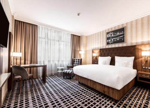 a hotel room with a bed and a desk at Hotel Grand City Wrocław in Wrocław