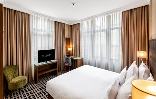 een hotelkamer met een bed en een televisie bij Hotel Grand City Wrocław in Wrocław