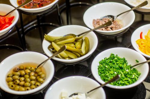 a bunch of bowls filled with different types of food at Hotel Grand City Wrocław in Wrocław