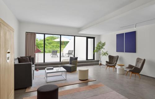 a living room with chairs and a couch and a table at Commune by the Great Wall, in the Unbound Collection by Hyatt in Yanqing