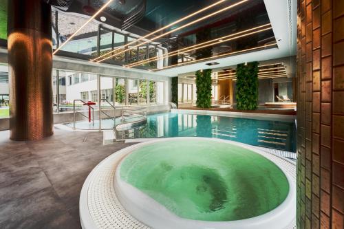 een groot zwembad met een hot tub in een gebouw bij ApartPark Baltic Home in Świnoujście
