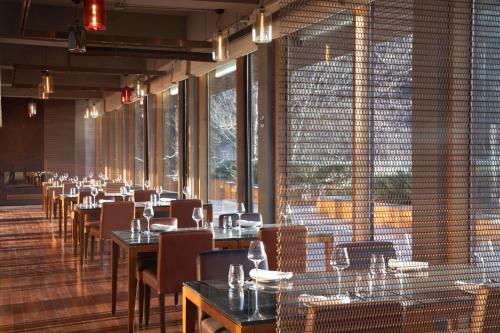 a restaurant with tables and chairs and large windows at Commune by the Great Wall, in the Unbound Collection by Hyatt in Yanqing