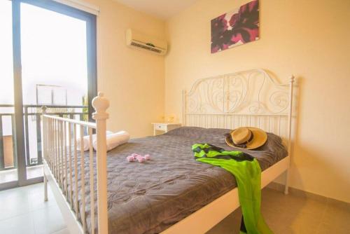 een slaapkamer met een bed met een hoed erop bij Protaras Allium Villa in Protaras