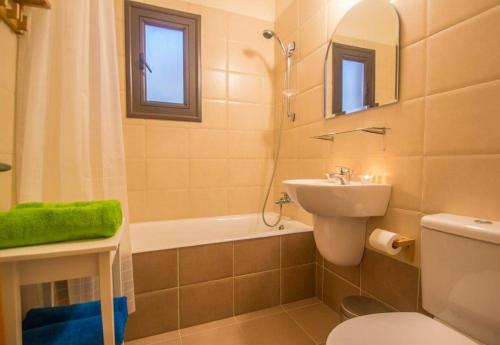 een badkamer met een wastafel, een toilet en een ligbad bij Protaras Allium Villa in Protaras