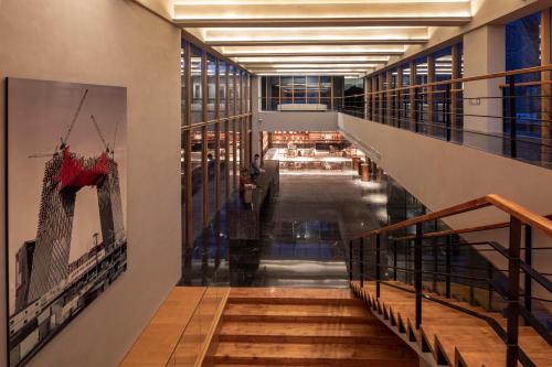 a hallway of a building with stairs and a painting on the wall at Commune by the Great Wall, in the Unbound Collection by Hyatt in Yanqing