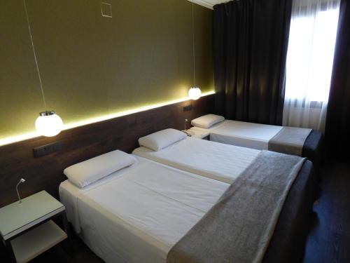 a hotel room with two beds and a window at Moderno in Barcelona