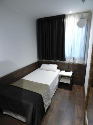 a small bedroom with a bed and a window at Moderno in Barcelona