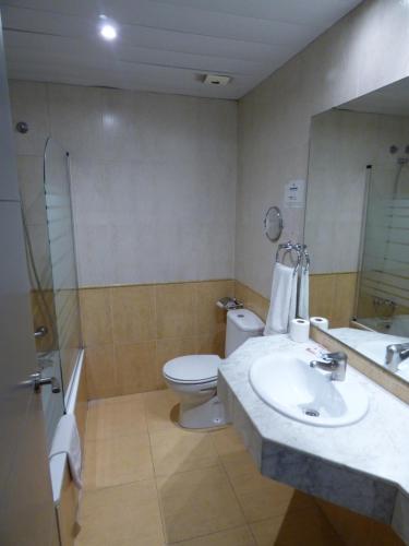 a bathroom with a sink and a toilet and a mirror at Moderno in Barcelona