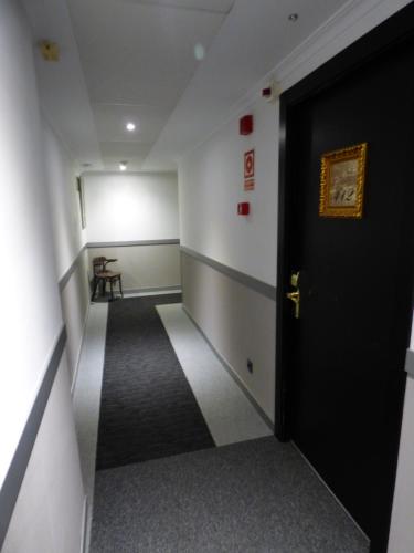 a hallway with a black door in a room at Moderno in Barcelona