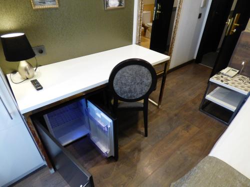 a desk with a chair in a room with a refrigerator at Moderno in Barcelona
