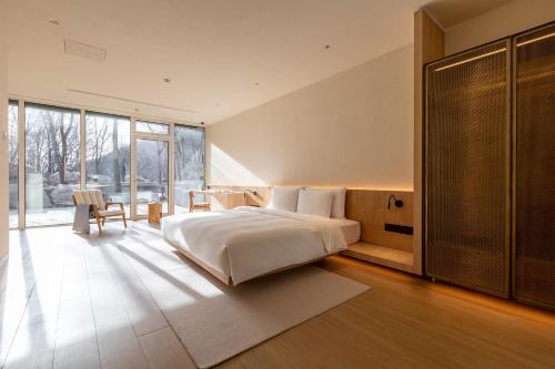 a bedroom with a large bed and a large window at Commune by the Great Wall, in the Unbound Collection by Hyatt in Yanqing