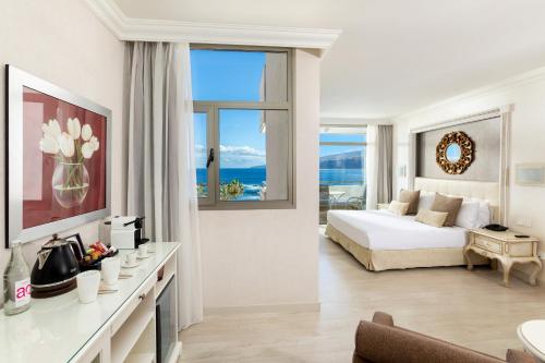 a hotel room with a bed and a large window at Sol Costa Atlantis Tenerife in Puerto de la Cruz