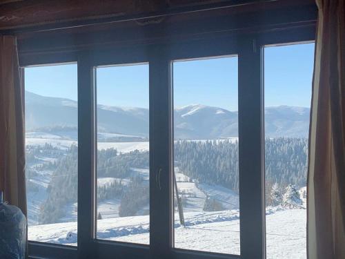 a window with a view of a snowy mountain at Monte Vista in Rostoka