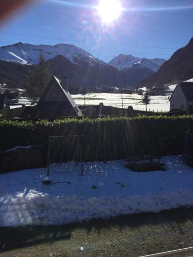a yard with snow and a fence and mountains at Appartment tourmalet in Campan