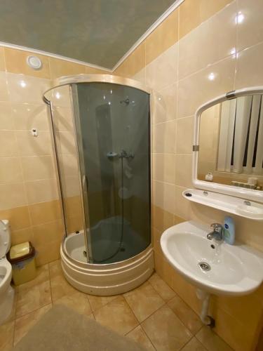a bathroom with a shower and a sink at Садиба "Джерело" in Yaremche