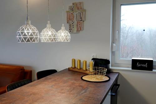 a dining room table with candles and pendant lights at Kuće za odmor -Japin breg in Ðurđevac