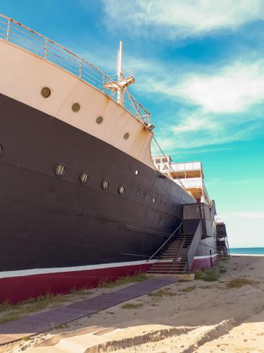 a large ship sitting on the beach next to the ocean at Superbe vue mer avec accès direct plage et parking in Le Barcarès