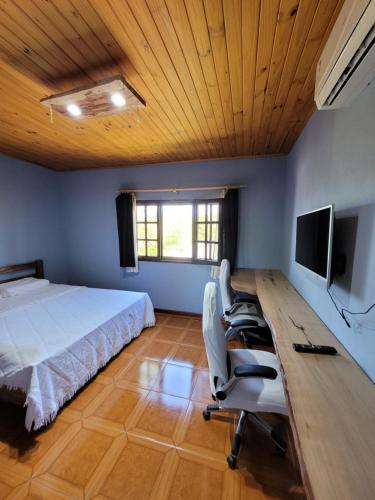 een slaapkamer met een bed en een bureau met een computer bij ELDOtown in Eldorado