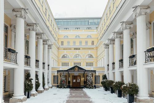 
a large building with a large clock on the front of it at The State Hermitage Museum Official Hotel in Saint Petersburg
