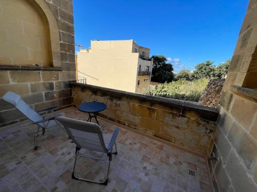 a balcony with two chairs and a table on it at Gilju B&B in Tal-Barmil