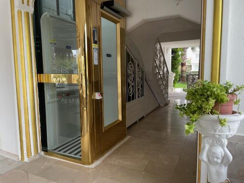 a door to a building with a plant in a vase at BELKA GOLF RESİDENCE Poolside apt1 Belek in Belek