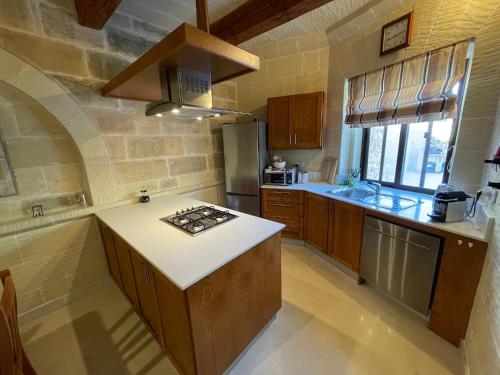 a kitchen with a stove and a counter top at Gilju B&B in Tal-Barmil