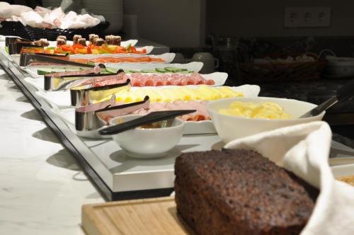 ストックホルムにあるLivington Hotelのテーブルの上にさまざまな種類の食べ物が並んだビュッフェ