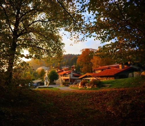 dom na środku podwórza z drzewami w obiekcie Agriturismo La Nevera w mieście Lanzo dʼIntelvi