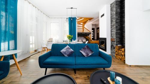 a living room with a blue couch and a table at Dom Sarnia 37, Sun & Snow in Karpacz