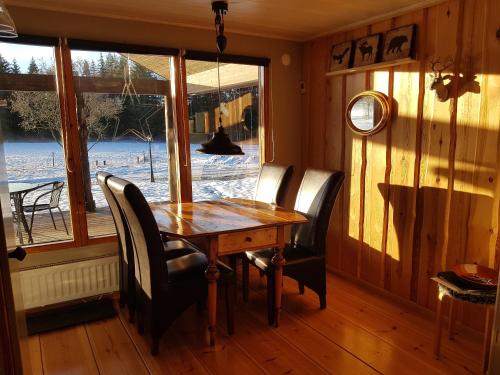 a dining room with a table and chairs and a window at Stordrågen in Kil