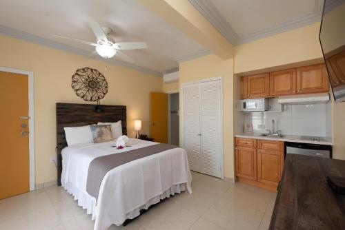 a bedroom with a large bed and a kitchen at Baker's Suites in Simpson Bay